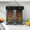 Excalibur food dehydrator with trays of food on a marble countertop