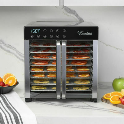 Excalibur food dehydrator with trays of food on a marble countertop