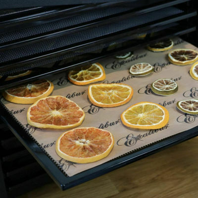 Citrus slices drying on an Excalibur ParaFlexx Premium non-stick sheet inside an Excalibur dehydrator.